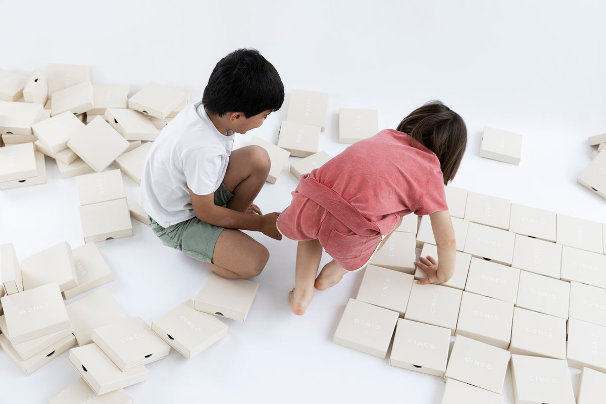 Kids engaging in creative activities for children's emotional development with boxes on the floor.