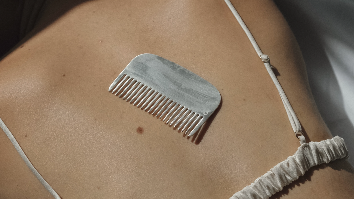 A silver comb placed on smooth skin, showcasing elegance and silver home decor accessories.