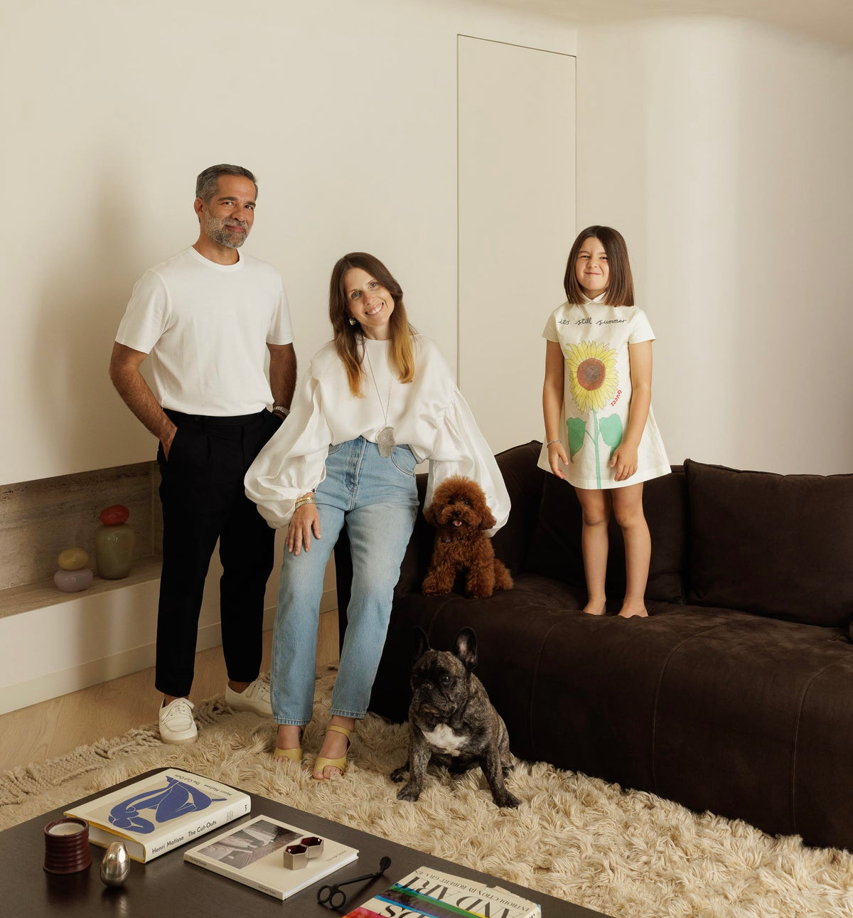 Family of three with two dogs in a living room
