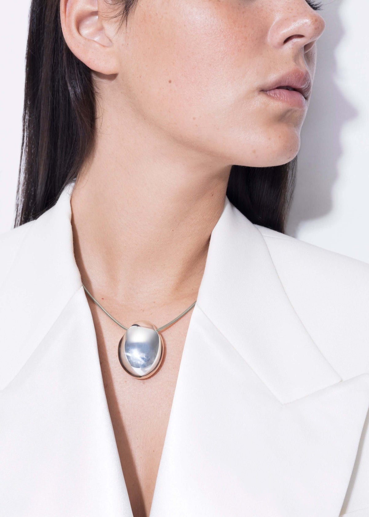 Elegant model wearing the handmade elegant Chéri necklace with a unique pendant design.