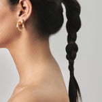 model wearing maxi jodie earrings and jodie huggies in gold
