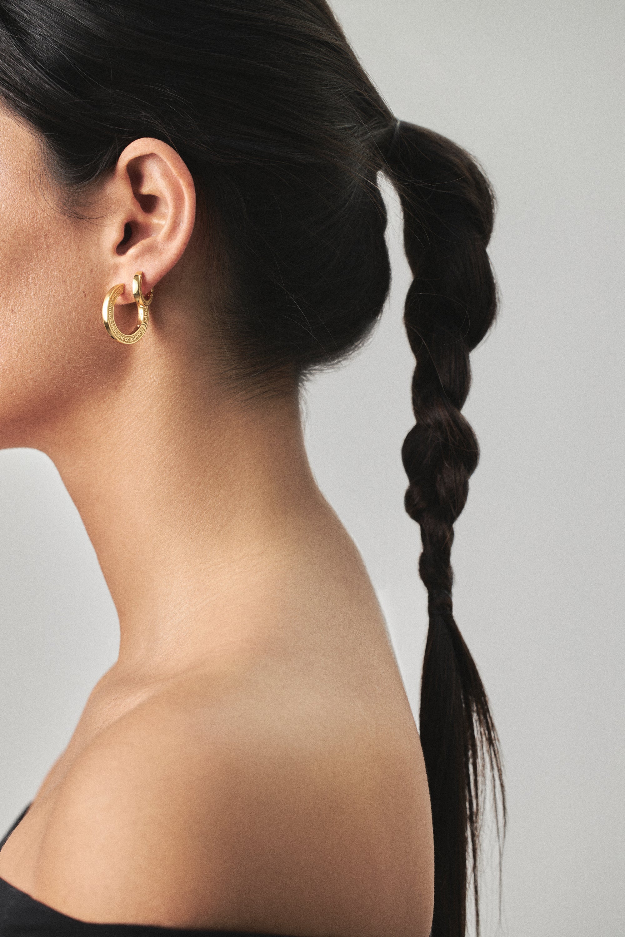 model wearing maxi jodie earrings and jodie huggies in gold