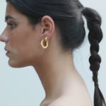 video of model wearing maxi jodie earrings and jodie huggies in gold