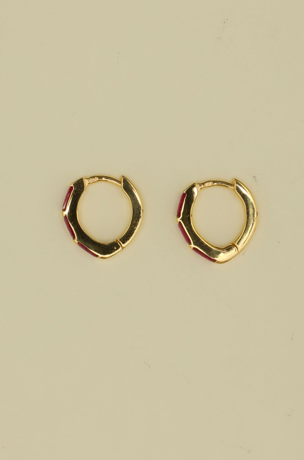 Gold hoop earrings on a beige background