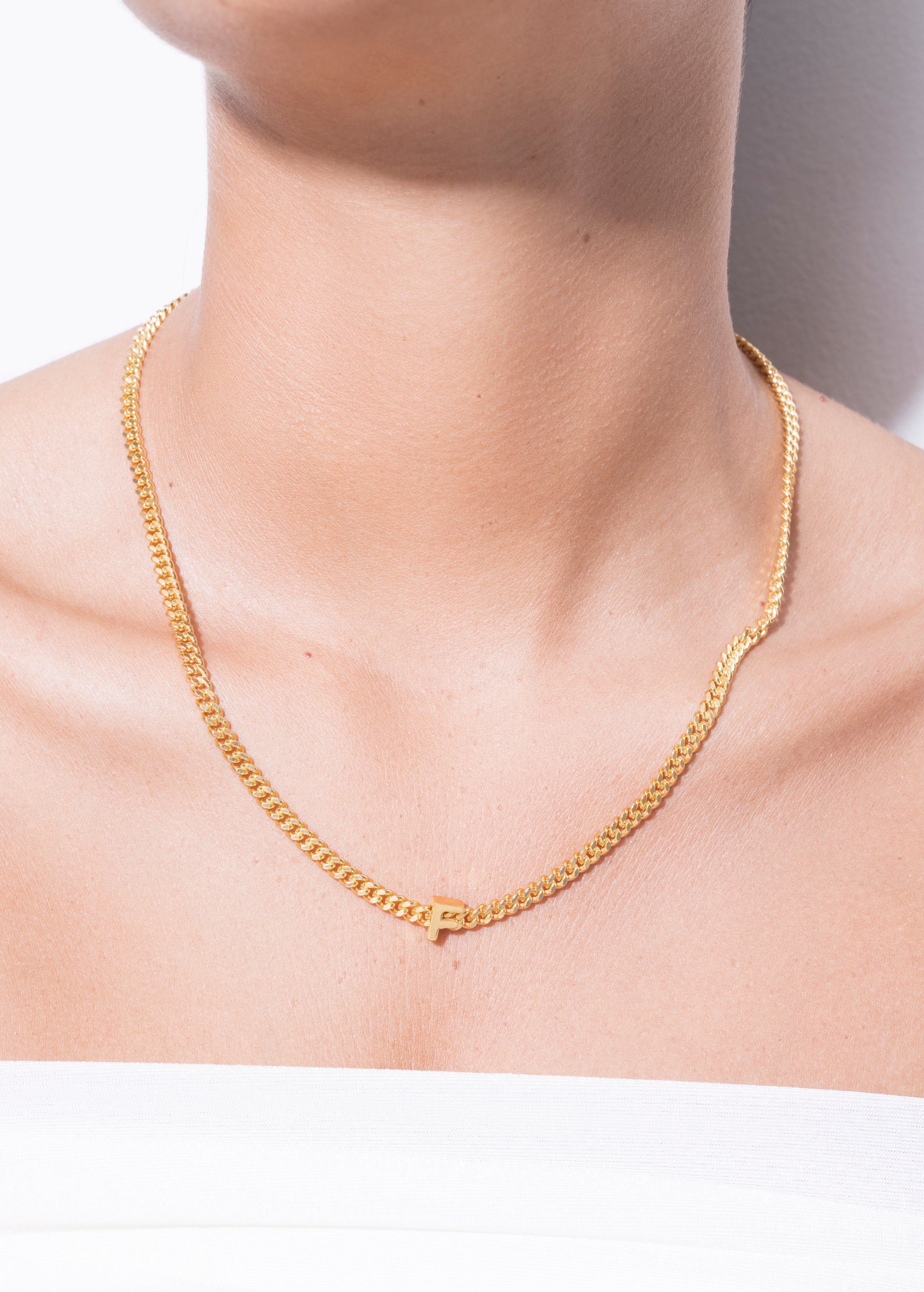 model wearing alphabet necklace with pendant F in gold