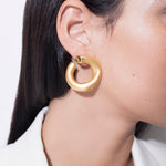 model wearing claudine earrings in gold