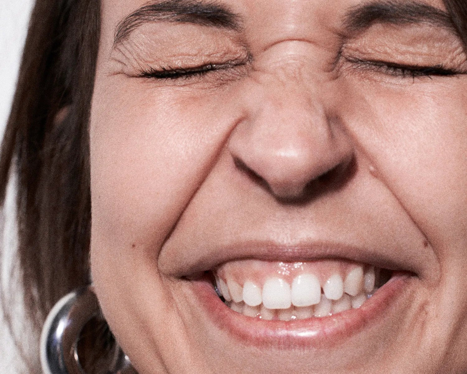 Close-up of a person with a neutral expression on a plain background