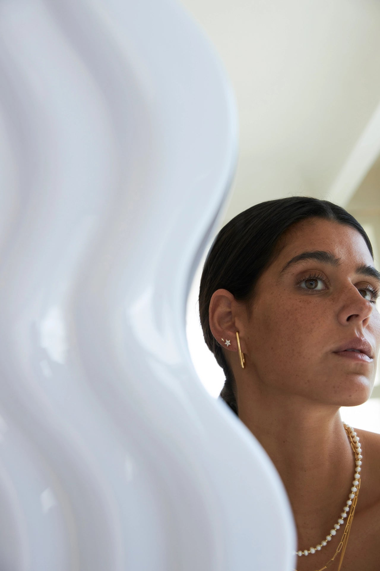 Woman wearing a pearl necklace and earrings with a blurred background