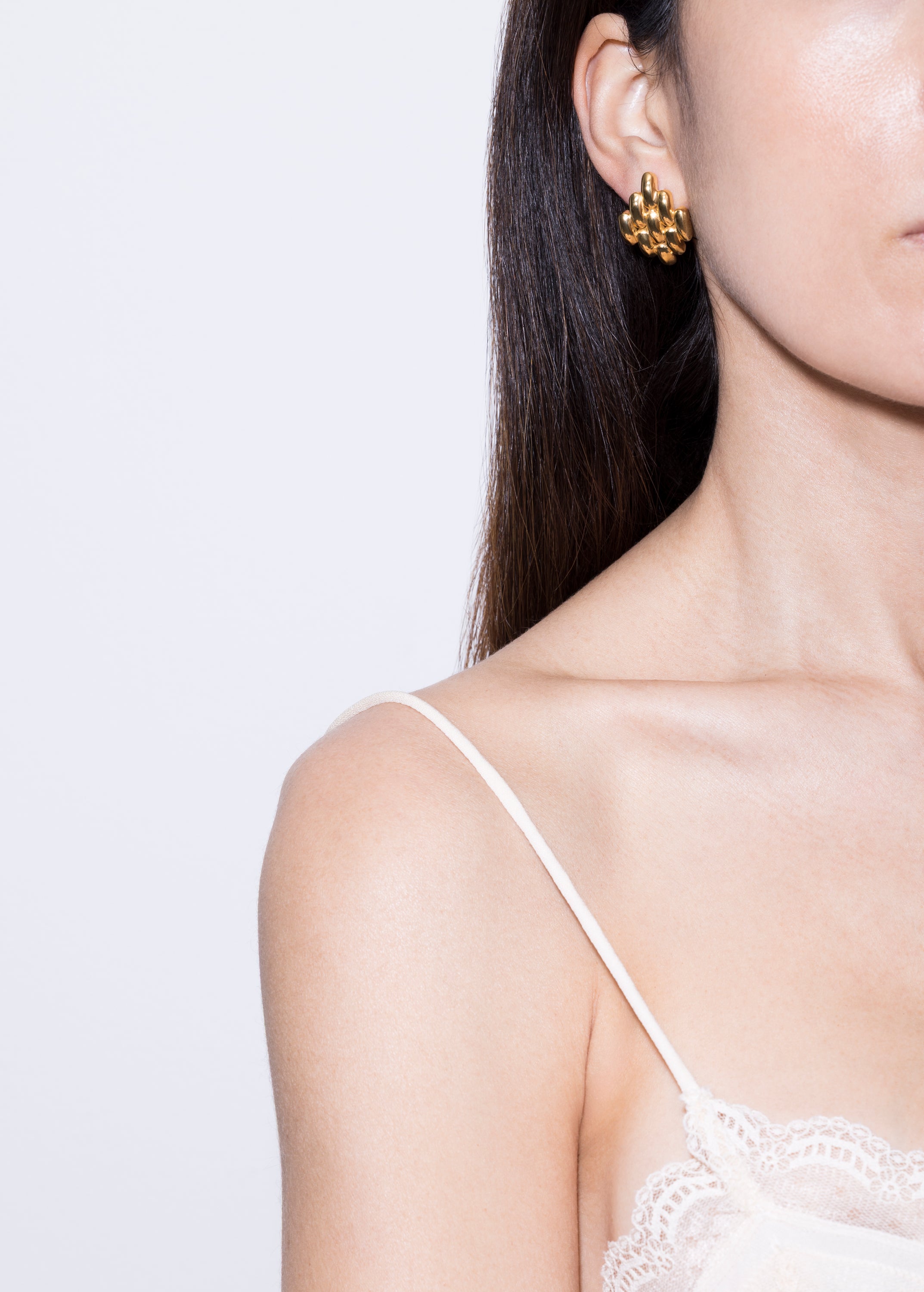 model wearing gala earrings in gold 