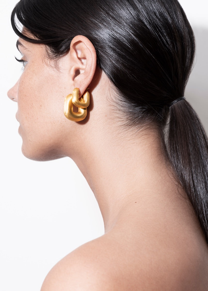 model wearing magda earrings and magda huggies in gold