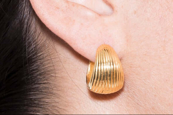 Bold handmade maxi earrings worn on ear, showcasing a striking gold design for standout style.