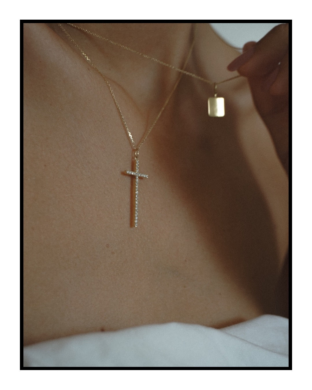 Close-up of a person wearing gold necklaces with pendants