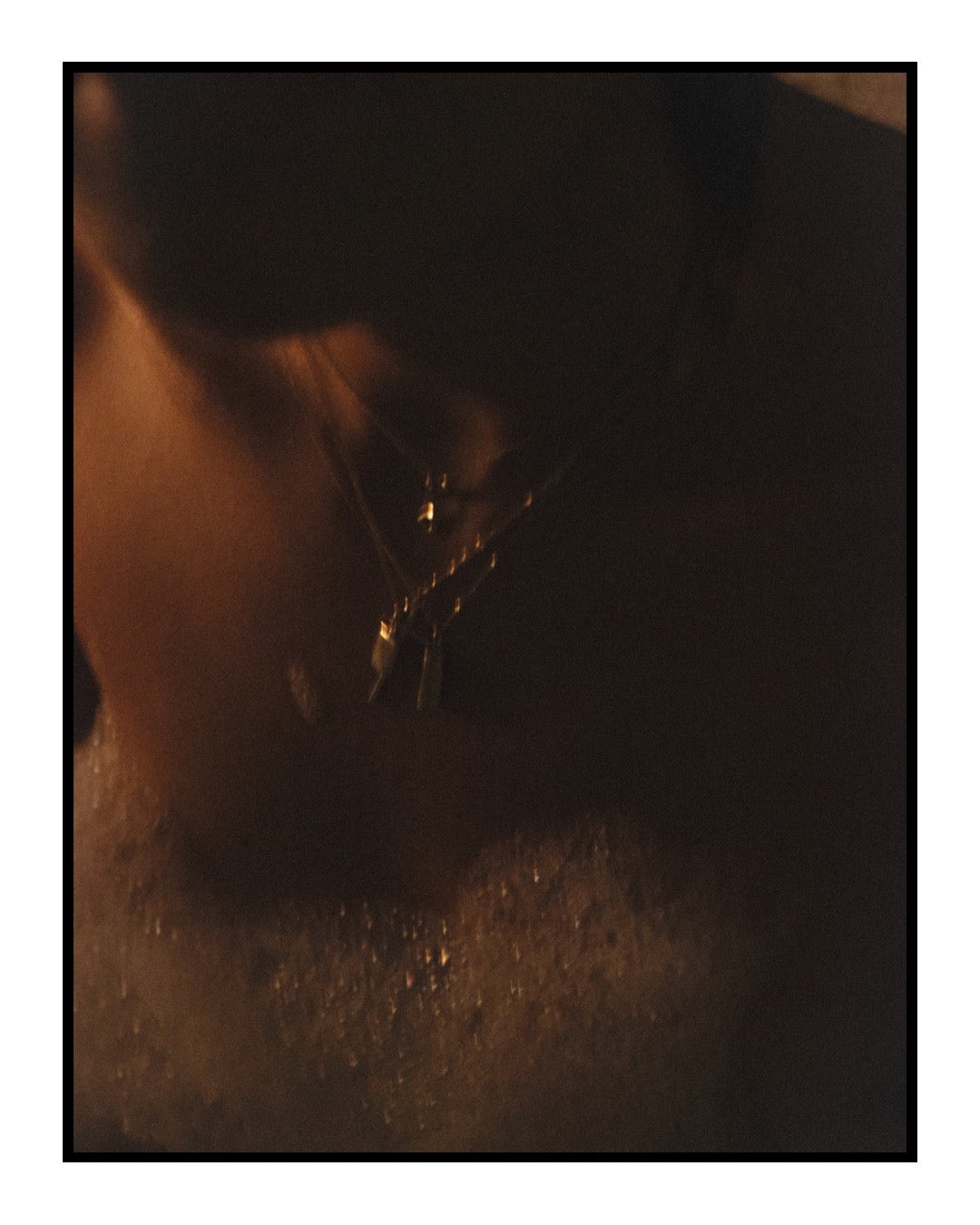 Close-up of a person wearing gold necklaces with pendants