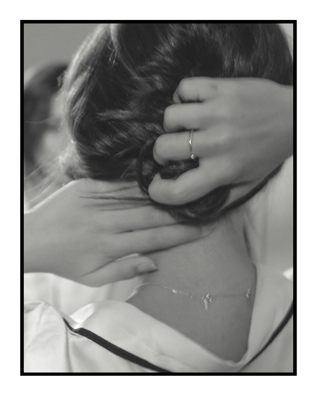 Person adjusting hair with a close-up of hands and a blurred background