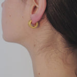 video of model wearing alma earrings in gold