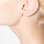 model wearing royals earrings in gold