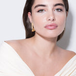 model wearing tina earrings in gold