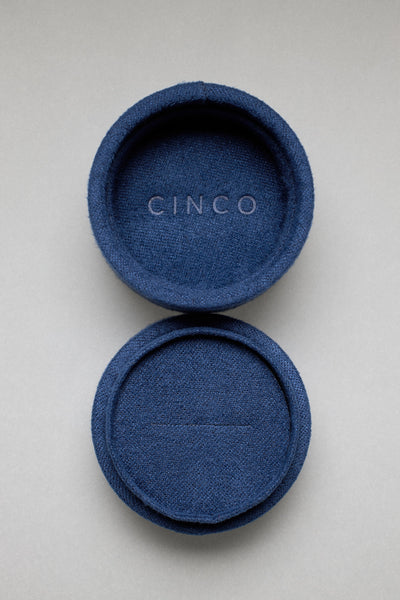 Tiny velvet jewelry box for travel, in blue, featuring the CINCO logo.